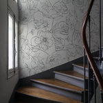 Staircase area enhanced by Dainty Skull Floral Wallpaper, which combines delicate floral artwork with subtle skull imagery in a soft gray on white background, adding an edgy yet sophisticated touch to the space