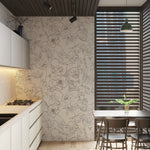 Contemporary kitchen with Dainty Skull Floral Wallpaper featuring a unique pattern of flowers intertwined with skulls in a monochromatic sketch style on a light background, creating a striking contrast with the modern white cabinetry and wooden details.