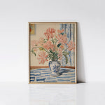 Mabel's Vase Floral Art Print displayed in a gold frame against a white wall, highlighting the vibrant pink flowers and intricate details of the blue and white vase