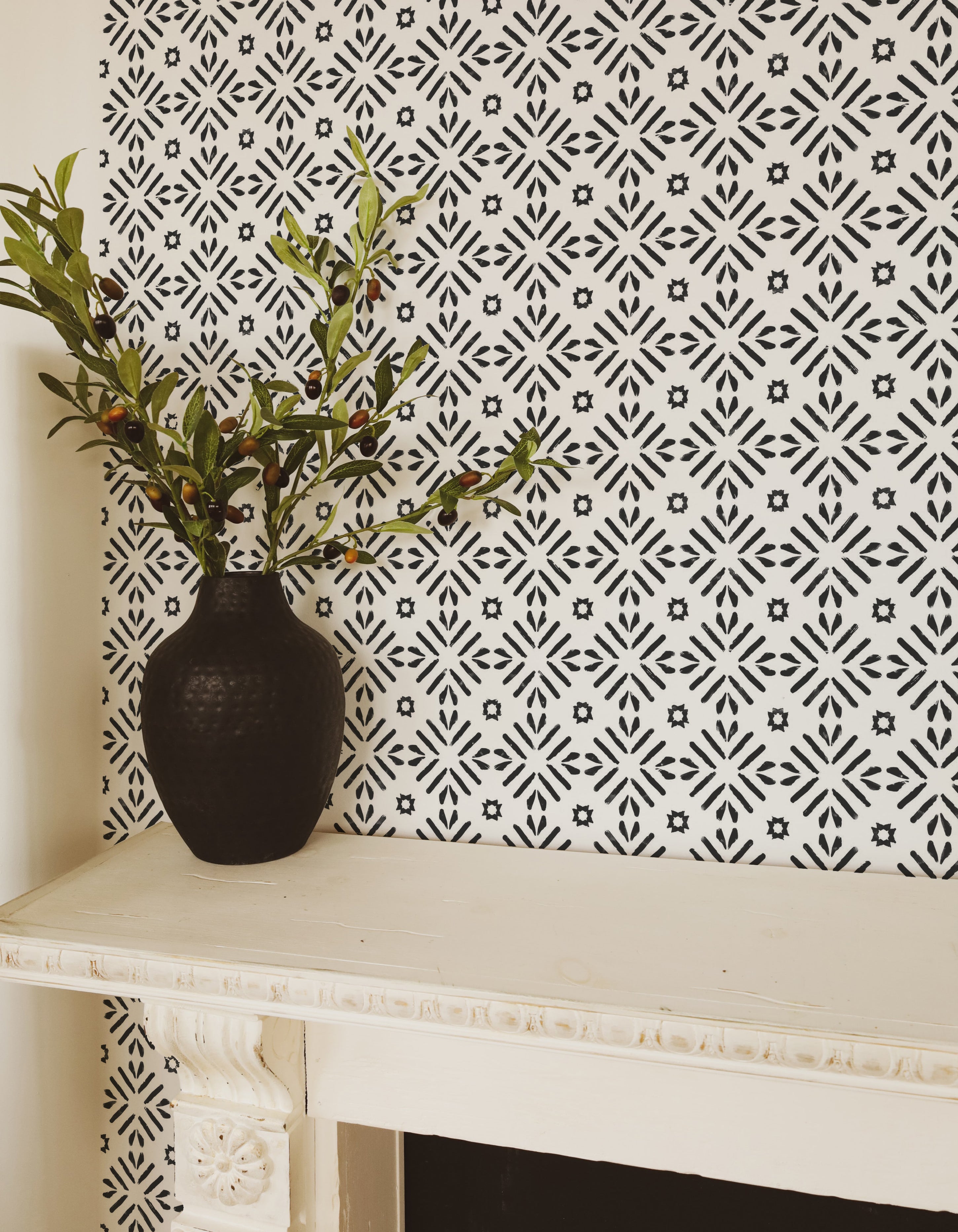 Elegant entryway decorated with Geometric Wallpaper III - Black, featuring a black vase with greenery against the striking black and white patterned wallpaper