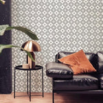 wallpaper, peel and stick wallpaper, Home decor, geometric wallpaper, living room wallpaper, black wallpapers, Stylish living room featuring Geometric Wallpaper III - Black with a complex pattern of white stars and geometric shapes on a black background, complemented by a black leather sofa and a modern copper lamp on a side table