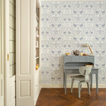 Vintage Floral Damask Wallpaper showcasing an elegant blue floral design in a room with a blue writing desk and chair, wooden flooring, and built-in white shelving.