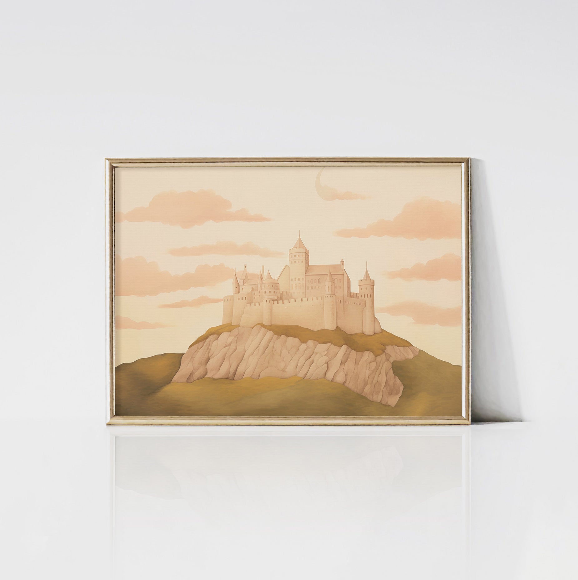 An art print of a whimsical pastel-colored castle framed in gold. The castle is set on a rocky hill with a backdrop of a dreamy sky filled with pink clouds, creating a magical and enchanting scene.