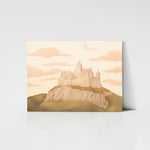 A charming art print of a pastel-colored castle mounted on a wooden board. The castle sits atop a rocky hill, framed by a soft sky filled with pink clouds, creating a whimsical and magical scene.