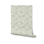 Roll of Soft Meadow Wallpaper - 25" showcasing the delicate pattern of small white flowers and green leaves on a soft sage background. The design is perfect for adding a touch of whimsy and charm to any room.