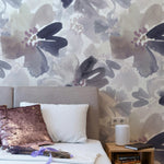 A full wall display of Purple Passion Wallpaper in a residential setting, illustrating the wallpaper's capability to transform a large space with its bold and artistic floral pattern in shades of purple and grey. The wallpaper serves as an impressive focal point in any room, offering both style and visual impact.