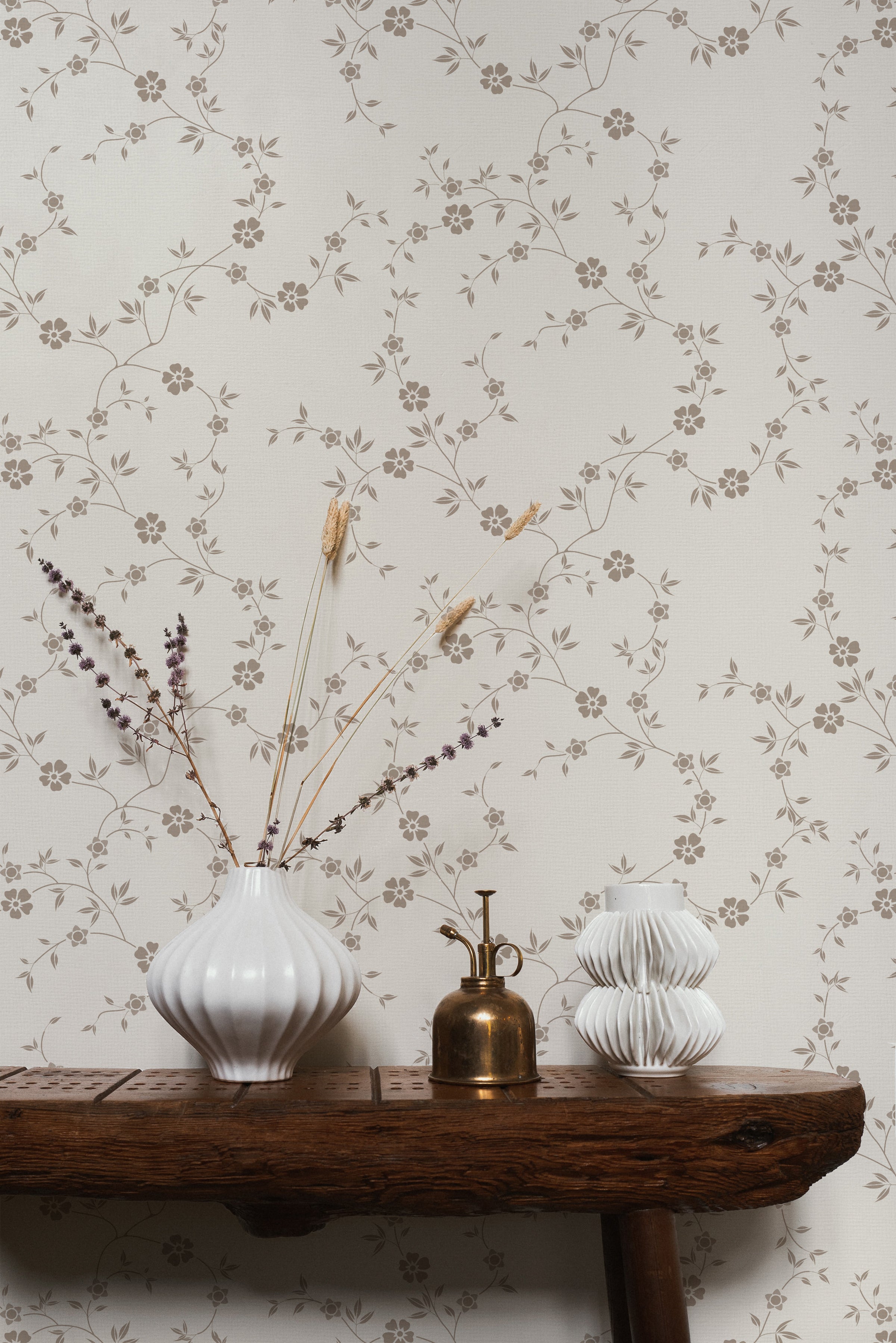 A close-up of 'Charming Floral Wallpaper', showcasing its intricate design of beige flowers connected by thin vines on a creamy background. The pattern radiates a vintage elegance, perfect for a timeless interior.