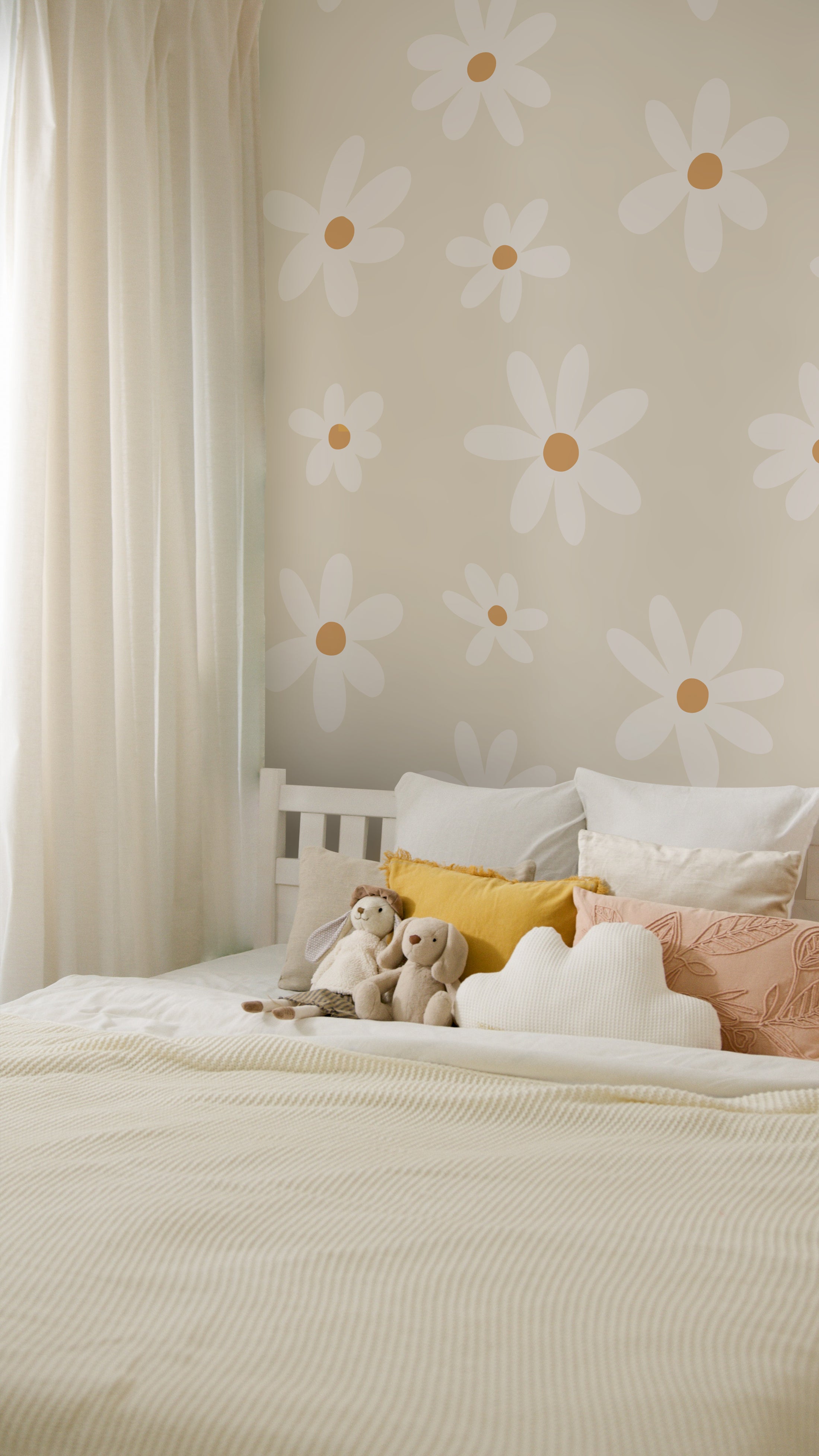 A cozy bedroom setting highlighting the Simple Daisy Wallpaper, creating a cheerful and inviting ambiance with its pattern of white daisies against an ecru background. The bed is dressed in neutral tones, accompanied by plush toys, evoking a sense of comfort and playfulness.