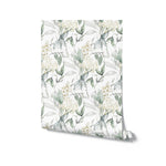 A roll of Heavenly Hydrangea wallpaper unrolled slightly to show the pattern. The wallpaper features an elegant design of white hydrangea flowers and soft green leaves, ideal for adding a touch of nature-inspired beauty to any space