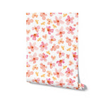 An image of a roll of Peachy Floral Wallpaper, highlighting the pattern of soft pink and peach flowers. This wallpaper roll is ideal for anyone looking to bring a bright, floral atmosphere to their living space, offering a blend of artistic charm and subtle color.