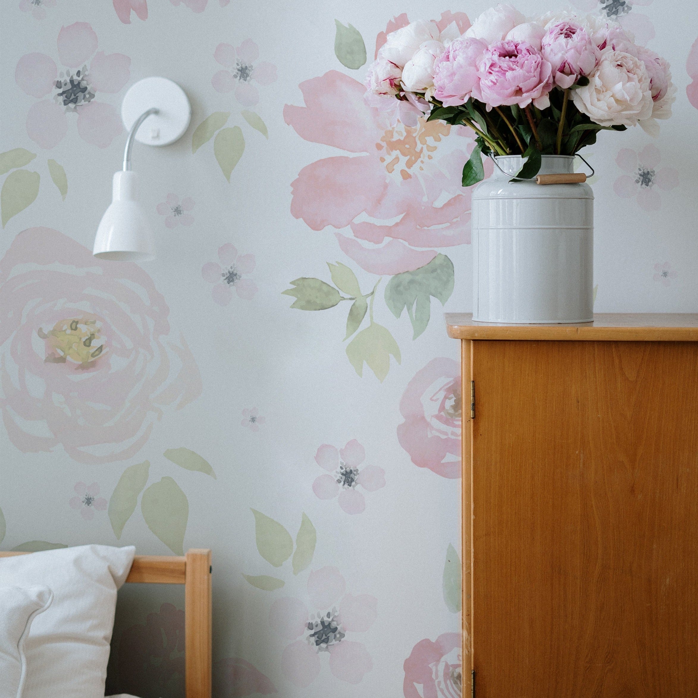 A corner of a bedroom with natural wood furniture, where a vase of fresh pink peonies on a nightstand complements the 'Gentle Blossom Wallpaper', enhancing the room's romantic and serene ambiance.