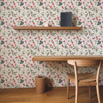 Elegant study area featuring Graceful Garden Wallpaper with a floral pattern of pink and red blossoms, green leaves, and butterflies on a light background. A minimalist wooden desk and chair set against the vibrant backdrop create a peaceful workspace.