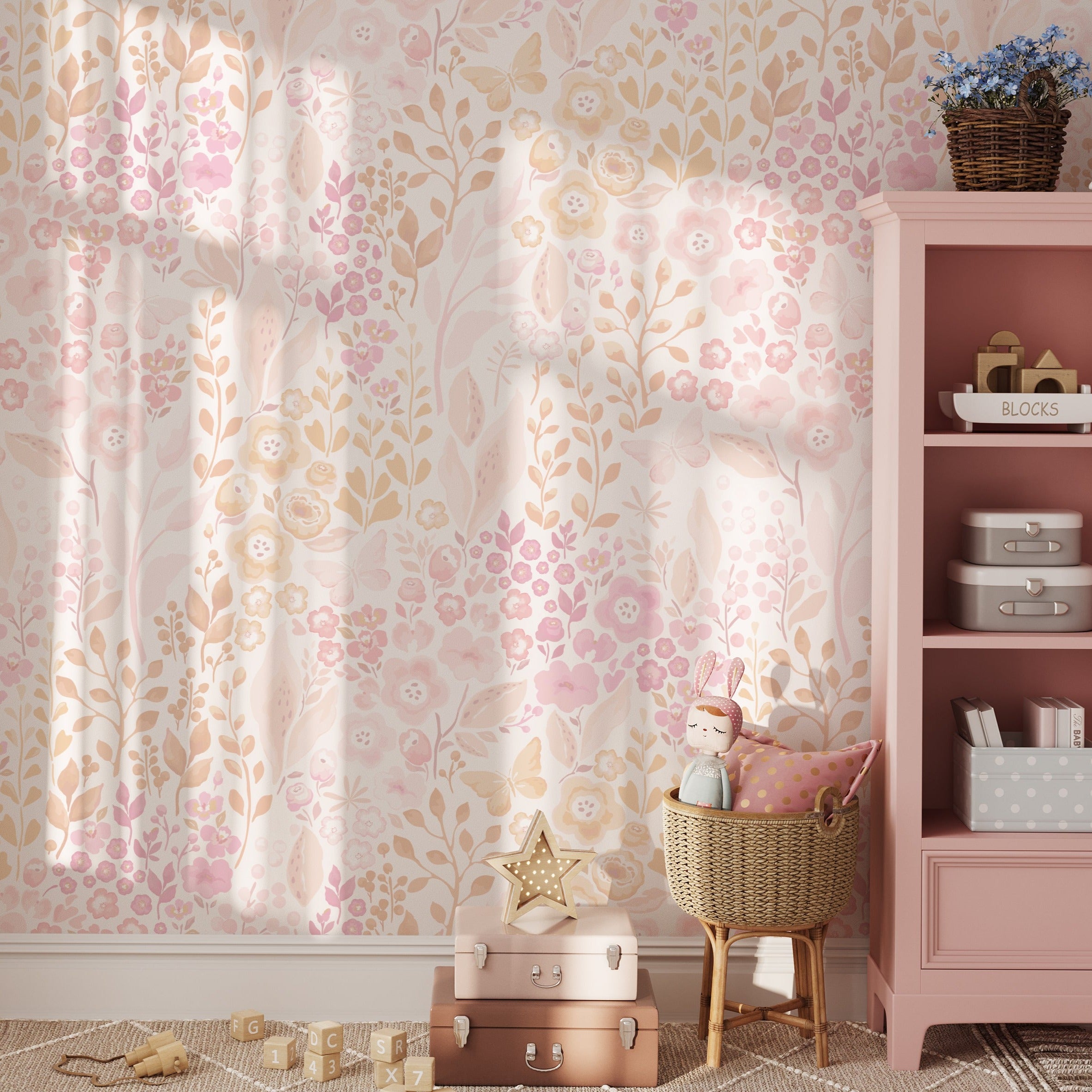 A cozy nursery corner graced with the 'Pretty Petals Wallpaper', providing a dreamy and tender setting for a child's room. The soft wallpaper pattern complements the pink shelving, plush toys, and star-shaped decor, creating a whimsical space for little ones.