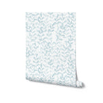 A roll of wallpaper featuring a light blue leafy pattern on a white background. The small leaves are arranged vertically, giving the design a cool and calming effect.