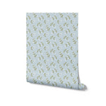 Roll of Simple Floral Wallpaper - 12.5" showcasing the delicate pattern of small white flowers and green leaves on a soft blue background. The design is perfect for adding a touch of whimsy and charm to any room.
