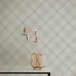 Royal Tartan Plaid Wallpaper featuring a sophisticated crisscross pattern in soft beige and cream tones, creating a timeless and elegant look in any room. A modern vase with abstract flowers complements the wallpaper on a minimalist table.