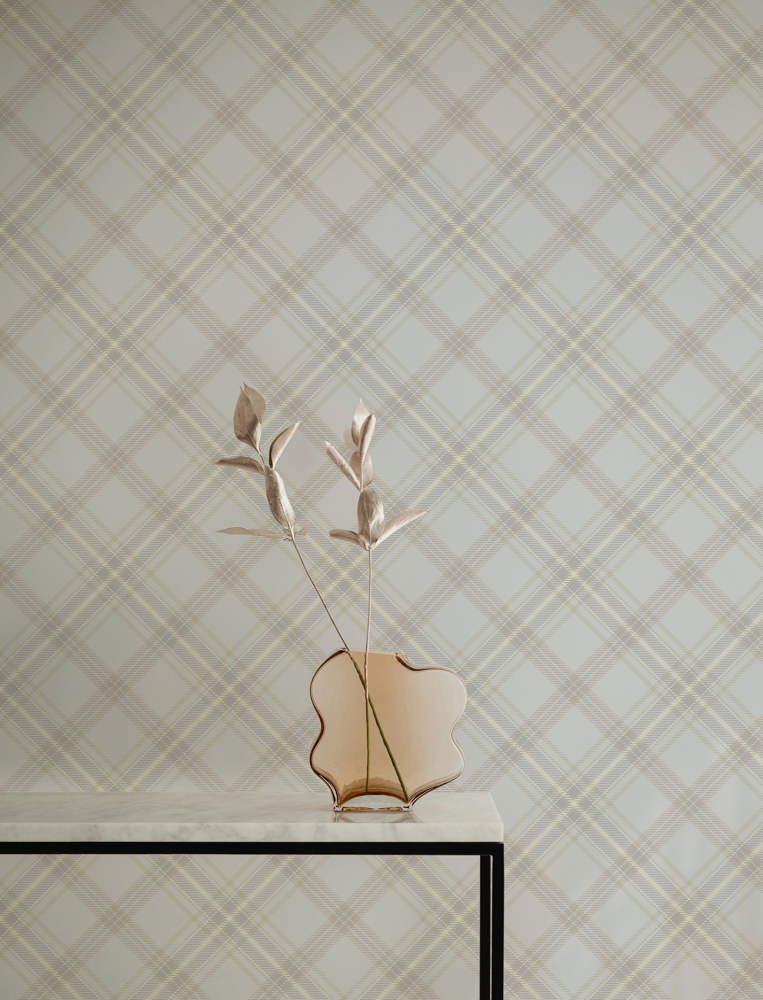 Royal Tartan Plaid Wallpaper featuring a sophisticated crisscross pattern in soft beige and cream tones, creating a timeless and elegant look in any room. A modern vase with abstract flowers complements the wallpaper on a minimalist table.