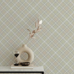 Tartan Plaid Wallpaper featuring a subtle crisscross design in beige and gray tones, adding a refined and elegant look to the room. A contemporary round vase with dried flowers and an hourglass timer on a white table complements the sophisticated decor