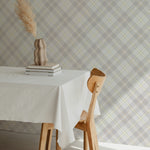 Misty Tartan Plaid Wallpaper featuring a subtle crisscross pattern in muted gray and beige tones, adding a touch of understated elegance to the dining room. A rustic vase with dried pampas grass sits atop a white tablecloth-covered dining table, enhancing the serene ambiance