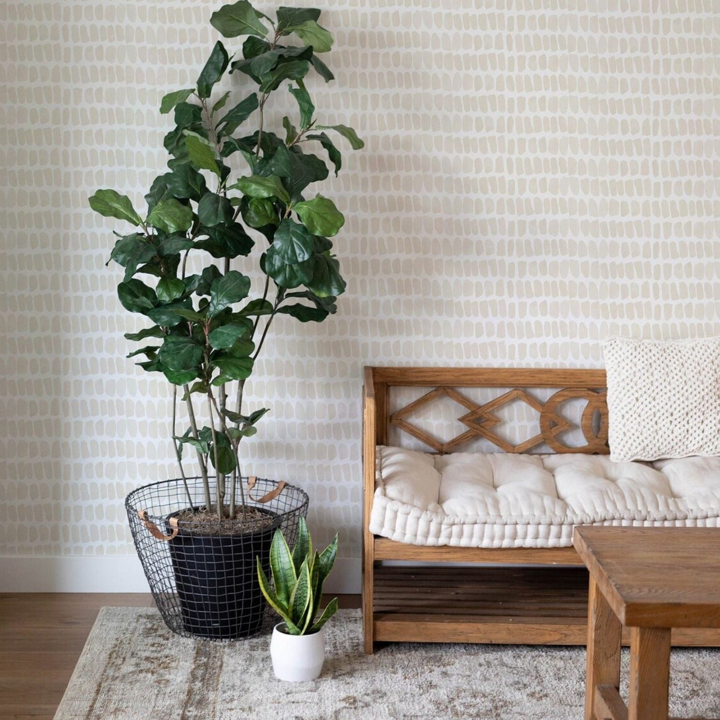 An interior setting where the Ecru Watercolour Dots Wallpaper is used to decorate a cozy corner. The wallpaper's subtle design complements the natural wooden furniture and the greenery of indoor plants, creating a relaxed and organic ambiance in the room. The image shows how the wallpaper can enhance a living space without overwhelming it.