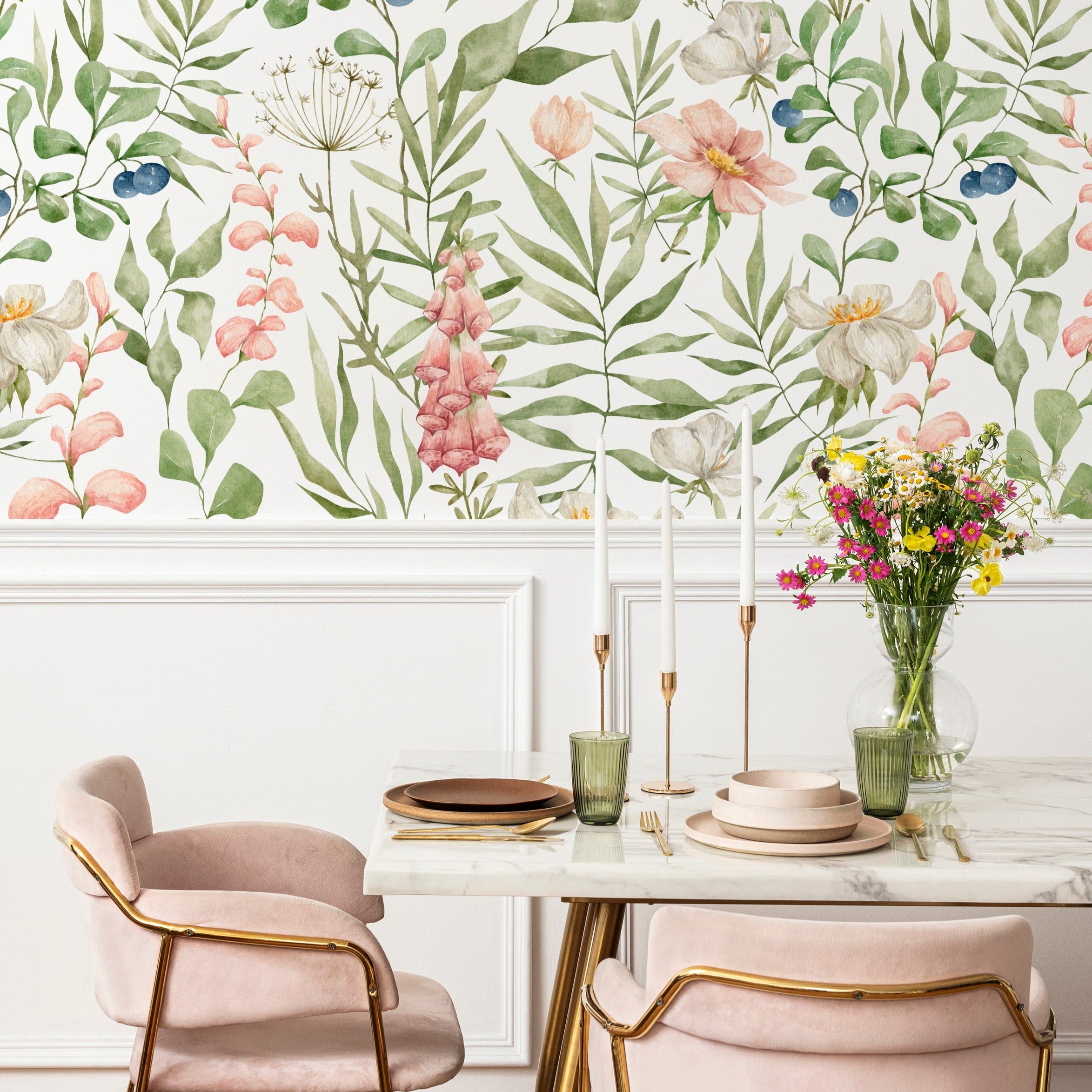 Elegant dining area enhanced by Watercolour Floral and Leaf Wallpaper II, with pastel floral patterns providing a soft backdrop to a modern table setting with pink chairs and a marble table.