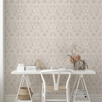 A minimalist workspace with Linen Morris Wallpaper as the backdrop. The light beige floral wallpaper complements the white modern desk and chair set, enhanced by natural wood accents and dried flowers for a calm, productive environment