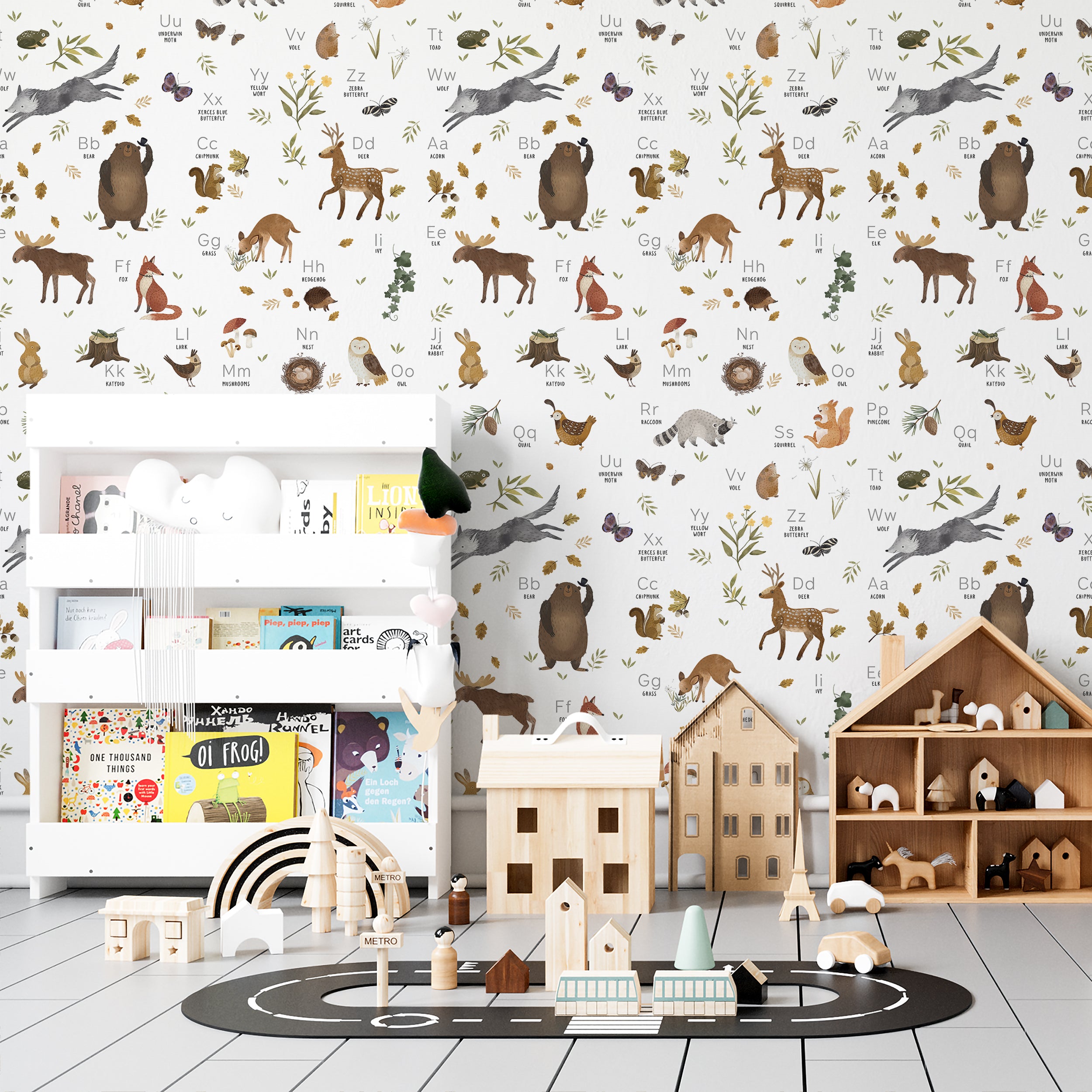 A child’s playroom decorated with Forest Alphabet Animal Wallpaper II. The wallpaper enriches the room with its educational and playful design, displaying various animals and alphabet letters. This backdrop complements a white toy storage unit and a playful, child-friendly interior setup
