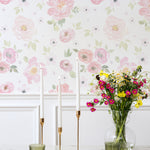 A close-up view of the Gentle Blossom Wallpaper - 25", displaying a delicate watercolor design of large pink and peach flowers with light green foliage. The soft pastel colors and floral arrangement provide a peaceful and elegant look, suitable for enhancing the beauty of any room.