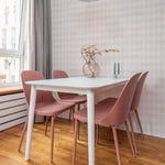 A dining area adorned with Rustic Watercolour Geometric Diamonds Wallpaper, creating a light and airy ambiance. The soft pink diamonds contrast beautifully with the modern white dining table and pink chairs, offering a fresh and inviting dining experience.