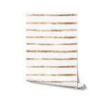 Rolled sample of Gold Stripes Wallpaper displaying alternating gold and white stripes with a textured appearance, perfect for adding an elegant and vibrant feature to any room.