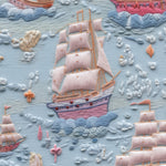 Close-up view of Breezy Sail Wallpaper, highlighting the detailed texture and colorful design of sailboats and fluffy clouds on a light blue background, perfect for a nautical-themed room.