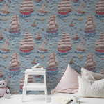 Children's room featuring Breezy Sail Wallpaper with a playful pattern of large sailboats on a textured blue background, styled with a white step stool and plush toys, creating a whimsical maritime theme.