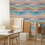 A creative workspace enhanced by the Sunset Sail Wallpaper, which brings a dynamic and colorful seascape to the environment. The setting includes a simple wooden desk and chair, highlighting the wallpaper's ability to inspire and brighten any space.
