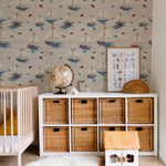 A nursery room enhanced with Windward Sail Wallpaper, where the repeating pattern of sailboats creates a serene maritime atmosphere. The room is styled with natural wood furniture and soft textiles, complementing the playful yet calm wallpaper design.