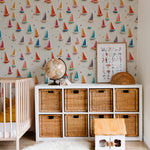 A nursery room with the 'Tidal Sail Wallpaper' enhancing a cheerful and playful environment. The room includes a baby's crib, wooden storage units, and a cozy white fur rug, creating a warm and inviting space.