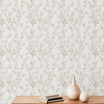 An elegant interior wall featuring the Vintage Floral Reverie Wallpaper, with intricate branches and delicate floral patterns in shades of muted pink and gray, creating a timeless, sophisticated look.