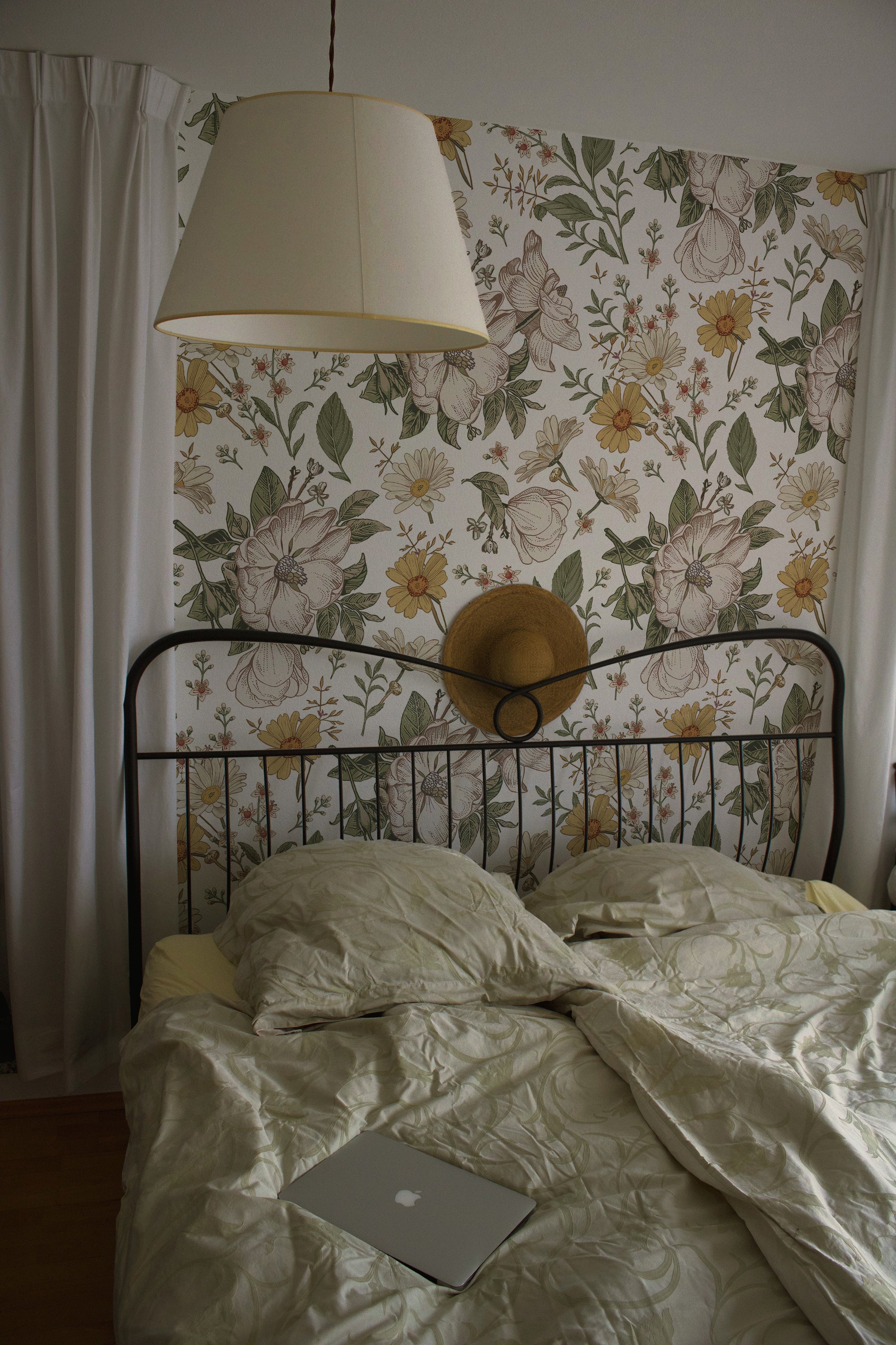a bedroom scene where the "Floral Wallpaper - Sunny II" adds a bright and cheerful background. The playful yet elegant pattern brings a sense of joy and serenity to the bedroom, pairing beautifully with the simple bedding and natural textures.