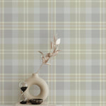 Interior with Heirloom Tartan Plaid Wallpaper, highlighting its classic tartan pattern in neutral shades of gray, beige, and white. The wallpaper creates a warm and inviting backdrop, accented by a stylish vase and decor on a console table.