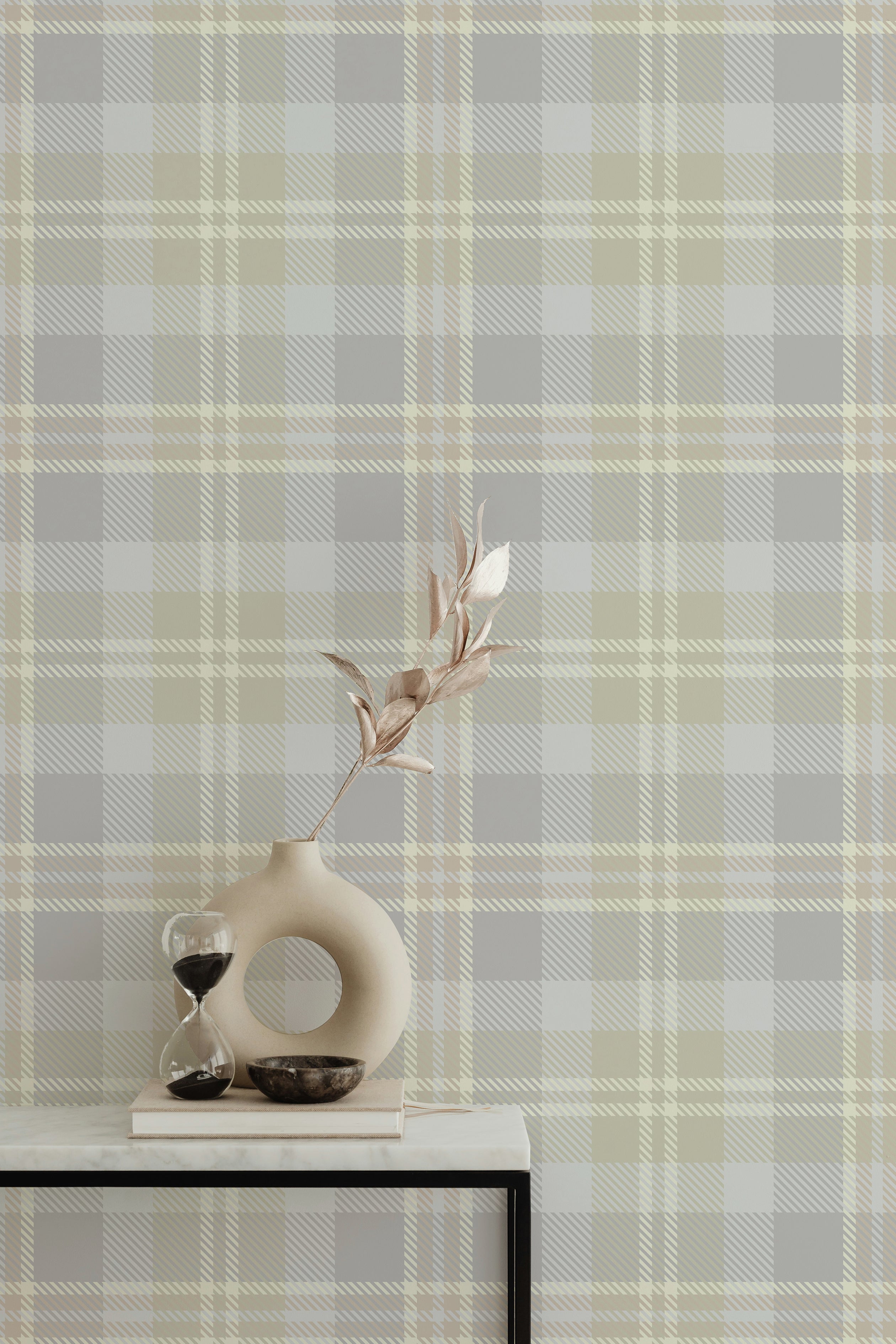 Interior with Heirloom Tartan Plaid Wallpaper, highlighting its classic tartan pattern in neutral shades of gray, beige, and white. The wallpaper creates a warm and inviting backdrop, accented by a stylish vase and decor on a console table.