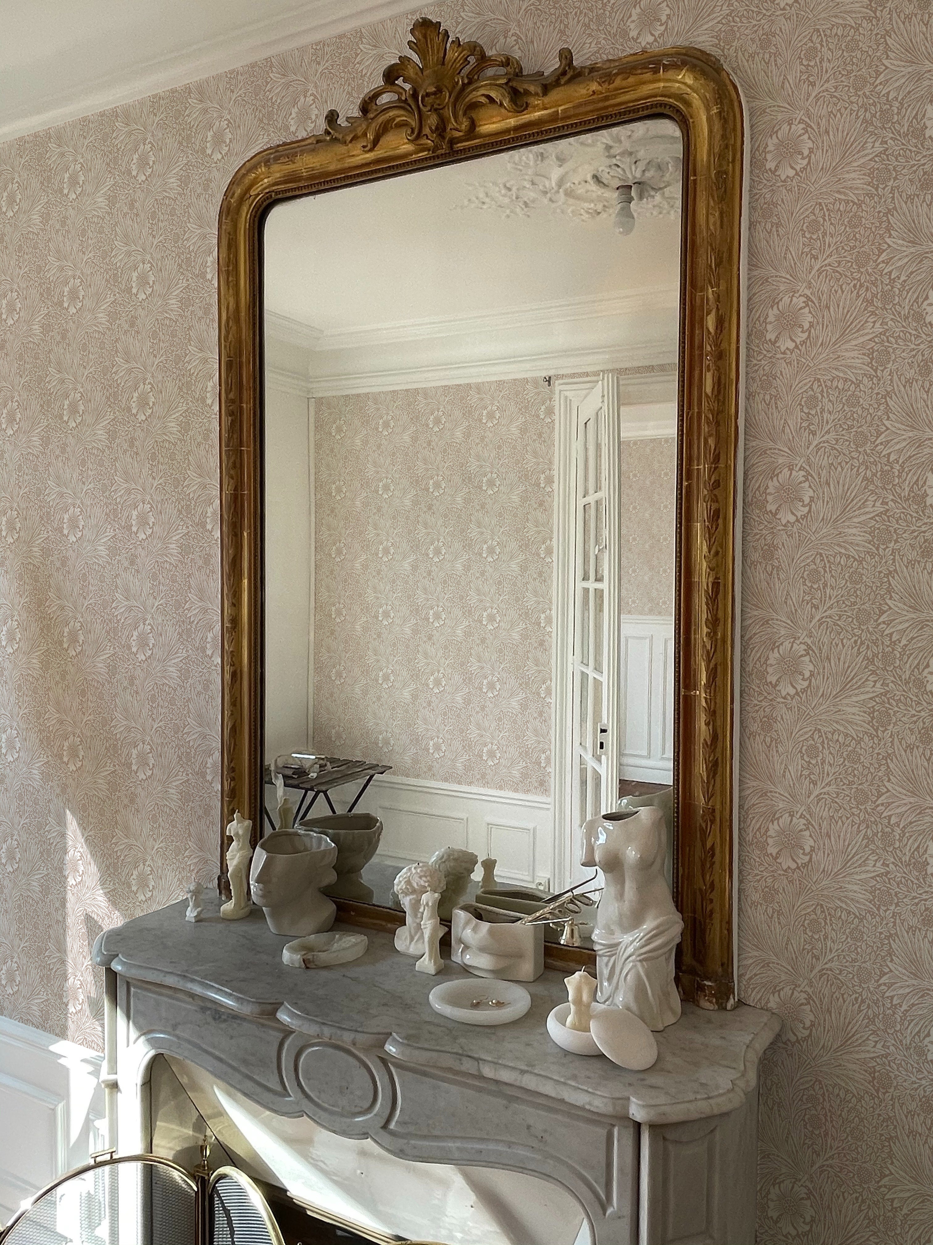 Charming dressing area featuring Timeless Floral Wallpaper with beige floral patterns, adding a vintage flair to the ornate mirror and decorative fireplace.