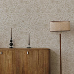 Close-up of Watercolour Paisley Wallpaper pattern with modern lamp and decor items on a wooden desk