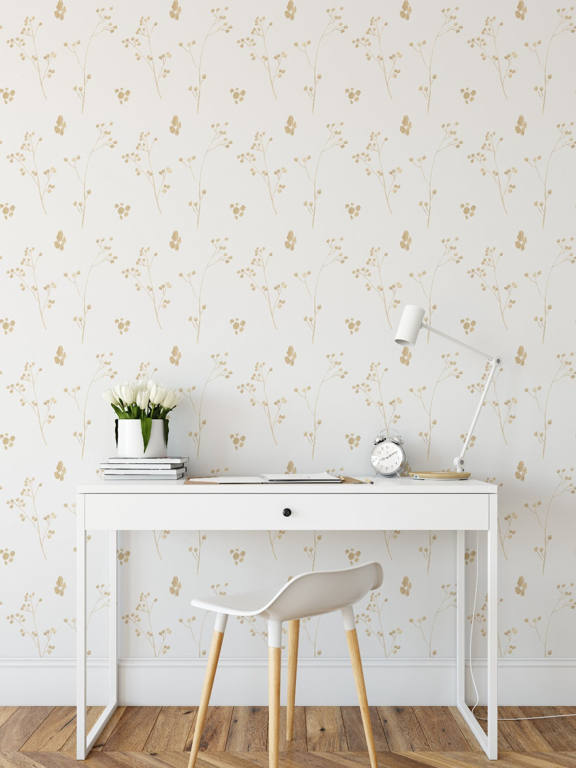 A sophisticated home office setup showcasing the Gold Collection Wallpaper III, with its understated golden floral pattern providing a luxurious backdrop to a clean, white desk and chair, accented by a bouquet of white tulips and a minimalist desk lamp.