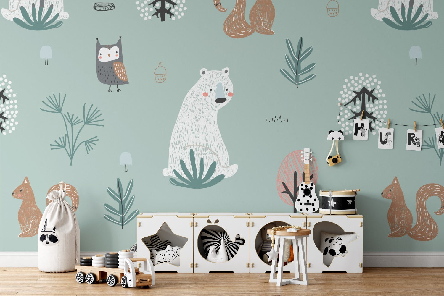 A playful and charming children's room with 'Forest Critters Kids Wallpaper' on the wall, featuring whimsical illustrations of woodland animals and plants in soft colors, above a child's storage unit filled with toys.