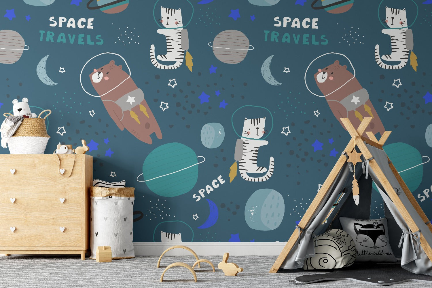 A lively room decorated with the same children's space-themed wallpaper. The walls feature adorable cats and bears in astronaut suits floating among planets and stars. The room is furnished with a wooden dresser, a cozy teepee, and playful decor, creating an adventurous and imaginative space.