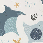 Close-up of the Kids Wallpaper - Smiley Rays, showing the delightful detail of the smiling aquatic creatures like stingrays and fish, along with starfish and sea-inspired doodles. The wallpaper's soft blue and beige palette exudes a gentle, soothing vibe for a child's nursery
