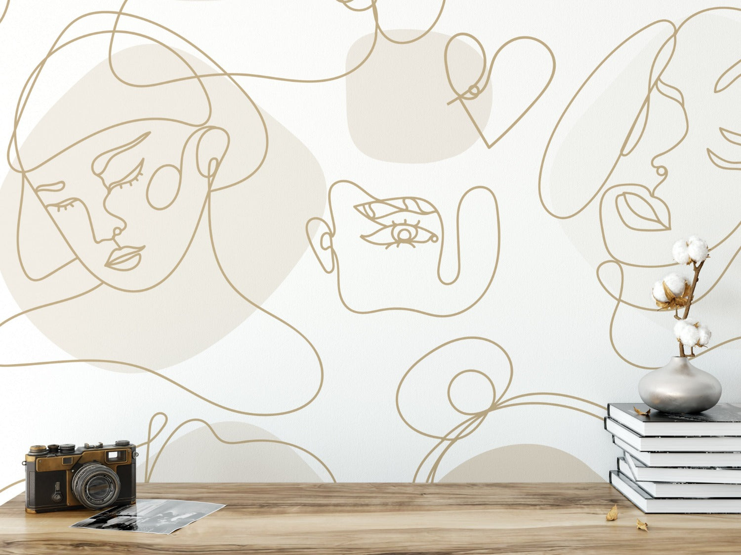 A modern and artistic wallpaper showcasing continuous golden line drawings of abstract faces on a white background. The faces are portrayed in various expressions and orientations, with some features highlighted by larger, shaded forms in the background.
