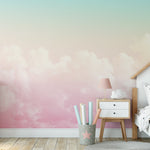 Child's bedroom with Pastel Sky Mural Wallpaper featuring a gradient of light pink to blue clouds.
