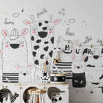 Nursery room decorated with animal wallpaper showing giraffe, bear, rabbit, and dog in cute outfits