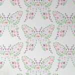 A close-up view of a wallpaper pattern with a creative design of butterflies formed by watercolor floral elements in gentle hues of pink, purple, and green, giving a delicate and enchanting appearance ideal for children's spaces