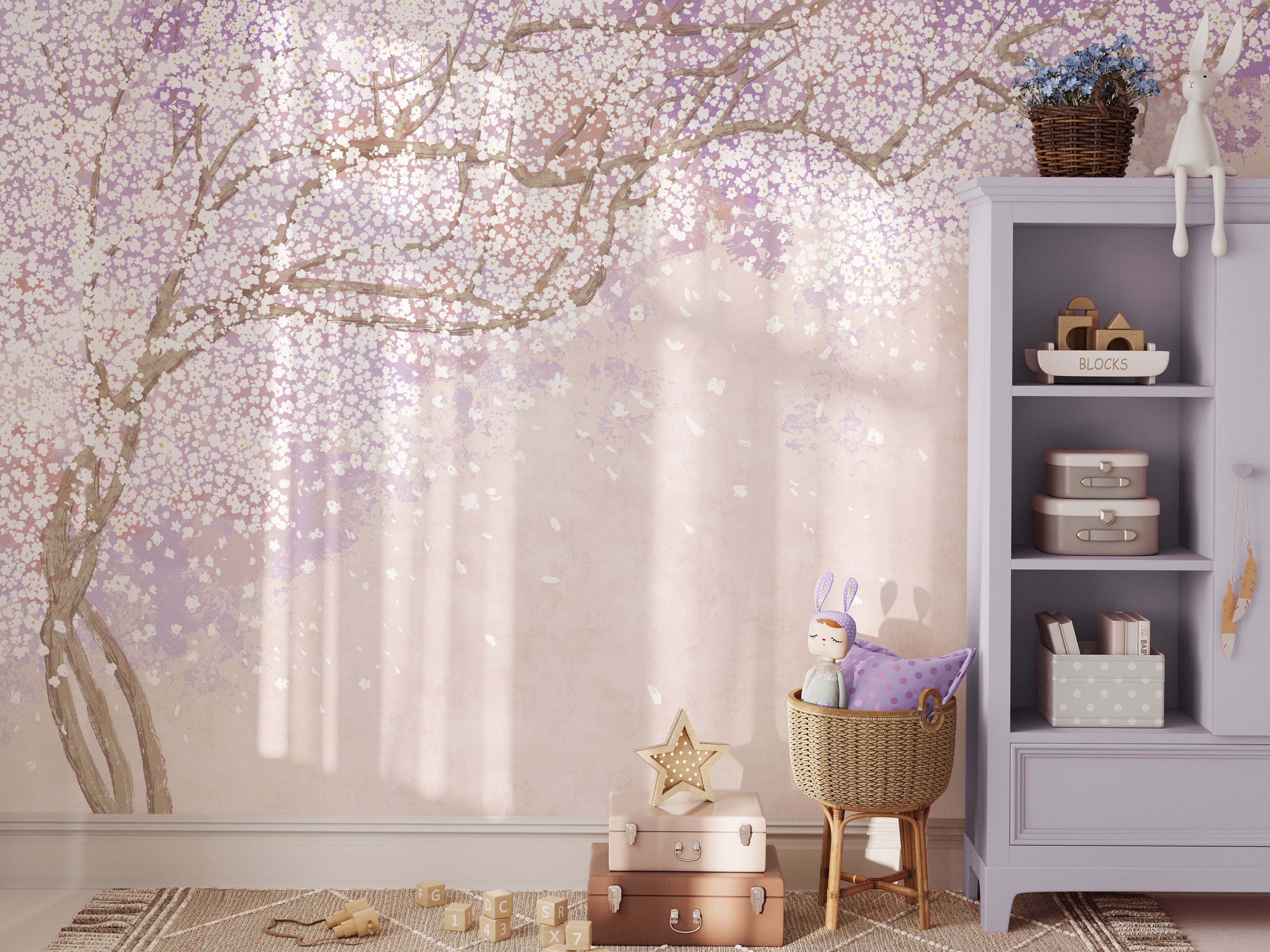 Sakura Nursery Kid Wallpaper Mural featuring a delicate cherry blossom tree with branches stretching across a pastel pink background, creating a serene and whimsical atmosphere in a child's room, complete with a cozy wicker basket, plush bunny toy, and a lavender bookshelf.